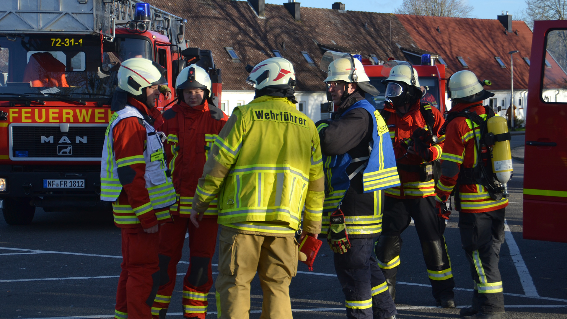 mehrere Feuerwehrmenschen stehen in einem Kreis